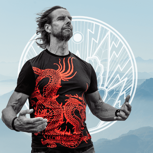 Jost Sauer in Qi Gong posture standing in front of mountains
